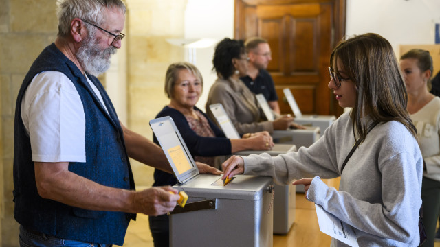 A woman casts her ballot during the Swiss Federal Elections in Delemont, Switzerland, 22 October 2023